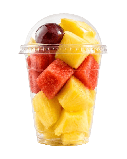 Vaso de fruta cortada tropical con piña, sandía y uva roja